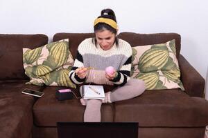 Woman showing the beginning of her crochet knitting during her online classes. photo