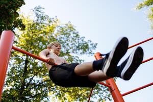 fondo ver de un Adolescente gimnasta ejecutando elementos. calle rutina de ejercicio en un horizontal bar en el colegio parque. foto