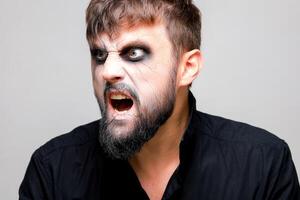 Portrait of a man with a beard and a menacing look with undead-style makeup on All Saints' Day on October 31 photo