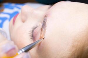 close-up brush held by the master and applied to the eyebrows laminating compositions photo