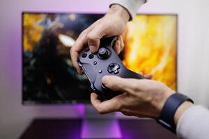 The man's hands are holding a gamepad that he's clutching. game gamepad in hand photo