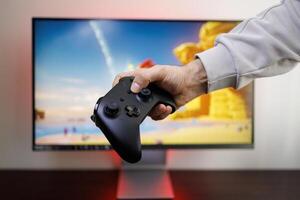 A black gamepad in the hands of a man. game gamepad in hand photo