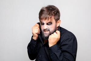 un hombre con un barba y maquillaje para Víspera de Todos los Santos hizo una mueca foto