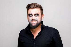 undead makeup for October 31 on a bearded man who shows teeth photo