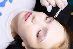 a close-up model of the eyebrow lamination procedure has laminating compositions applied to the eyebrows photo