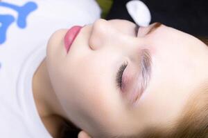 a close-up model of the eyebrow lamination procedure has laminating compositions applied to the eyebrows photo