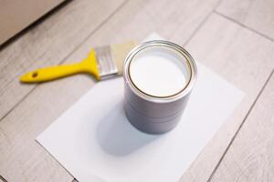 Close-up of a can of white paint for painting. Repair staining the doors with paint. photo