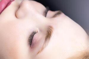 close-up of the model's combed eyebrows with the help of laminating compositions photo