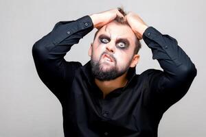 halloween and makeup for a bearded man who tears the hair on his head photo