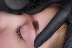 Macrophotograph of eyebrows with applied permanent makeup with leached pigment. PMU Procedure, Permanent Eyebrow Makeup. photo