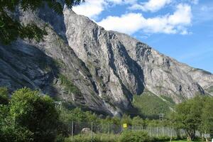 The Troll Wall Trollveggen mountain massif Trolltindene Troll Peaks in the Romsdalen valley, Norway. Rauma railway through Romsdalen Valley, Andalsnes, Norway photo