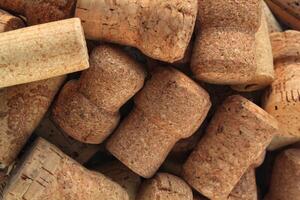 Pile of natural wooden wine corks close up as background. Concept of environmental protection and waste separation. Recycled closures used for sealing wine bottles photo