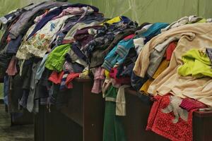 humanitario ayuda centrar de apoyo y ayuda pobre, refugiado y Vagabundo gente. ahorrativo almacenar. circular moda, donación, caridad. Clásico ropa tienda foto