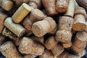 Pile of natural wooden wine corks close up as background. Concept of environmental protection and waste separation. Recycled closures used for sealing wine bottles photo