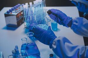 chemist,scientist hand dropping chemical liquid into test tube, science research and development concept photo