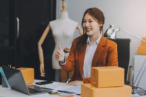 Starting Small business entrepreneur freelance,Portrait young woman working at home office, BOX,smartphone,laptop, online, marketing, packaging, delivery, SME, e-commerce concept photo