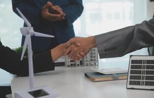 Construction workers holding helmets and vests are shaking hands. real estate concept Architect shaking hands with engineer or builder planning and successful meetings photo