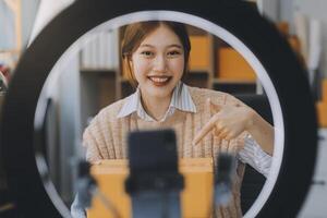 Young woman freelancer working sme business online shopping and packing clothes with cardboard box at home - Business online shipping and delivery concept photo