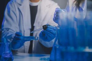 chemist,scientist hand dropping chemical liquid into test tube, science research and development concept photo