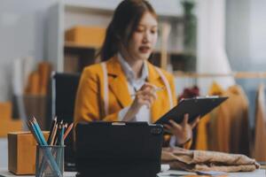 Emprendedora de pequeñas empresas o mujer asiática independiente que usa una computadora portátil con caja, joven mujer asiática de éxito con su mano levantada, caja de embalaje de marketing en línea y entrega, concepto de pyme. foto