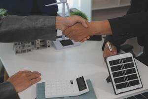 Construction workers holding helmets and vests are shaking hands. real estate concept Architect shaking hands with engineer or builder planning and successful meetings photo