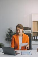 Portrait of Asian young female working on laptop photo