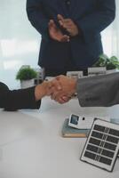 Construction workers holding helmets and vests are shaking hands. real estate concept Architect shaking hands with engineer or builder planning and successful meetings photo