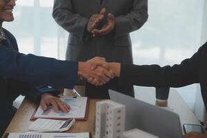 Estate agent shaking hands with customer after contract signature photo