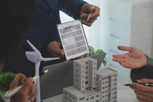 Team of architectures and businessman are discussing and brainstorming on floor plan modification for real estate sustainable investment and solar energy housing development project photo