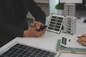 Team of architectures and businessman are discussing and brainstorming on floor plan modification for real estate sustainable investment and solar energy housing development project photo