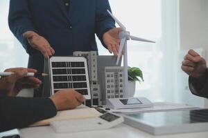 Team of architectures and businessman are discussing and brainstorming on floor plan modification for real estate sustainable investment and solar energy housing development project photo