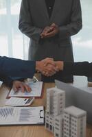 Estate agent shaking hands with customer after contract signature photo