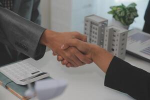 Construction workers holding helmets and vests are shaking hands. real estate concept Architect shaking hands with engineer or builder planning and successful meetings photo