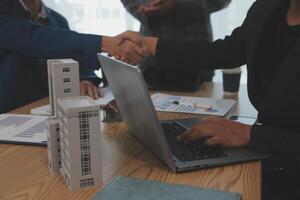 Estate agent shaking hands with customer after contract signature photo