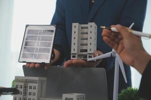 Team of architectures and businessman are discussing and brainstorming on floor plan modification for real estate sustainable investment and solar energy housing development project photo