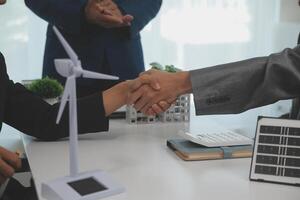 Construction workers holding helmets and vests are shaking hands. real estate concept Architect shaking hands with engineer or builder planning and successful meetings photo