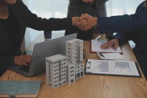 Estate agent shaking hands with customer after contract signature photo