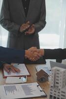 Estate agent shaking hands with customer after contract signature photo