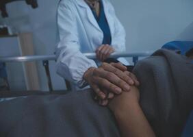 Cropped shot of a female nurse hold her senior patient's hand. Giving Support. Doctor helping old patient with Alzheimer's disease. Female carer holding hands of senior man photo