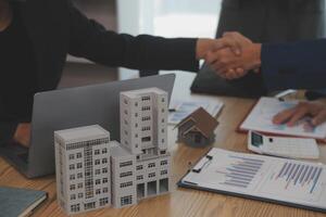 Estate agent shaking hands with customer after contract signature photo