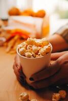 un mujer participación un cuenco de palomitas de maiz foto