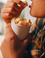 un mujer participación un cuenco de palomitas de maiz foto