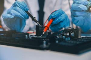 Close up of Technician measuring voltage electronic circuit board television, Service after sale fix electric equipment within insurance. photo