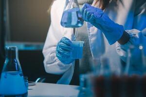 chemist,scientist hand dropping chemical liquid into test tube, science research and development concept photo