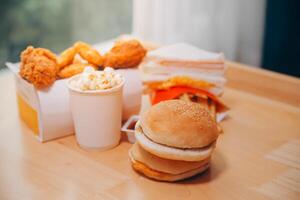 fast food, people and unhealthy eating concept - close up of woman hands holding hamburger or cheeseburger photo