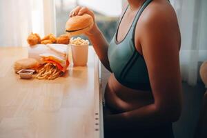 Binge eating disorder concept with woman eating fast food burger, fired chicken , donuts and desserts photo