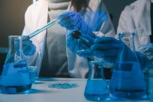 chemist,scientist hand dropping chemical liquid into test tube, science research and development concept photo