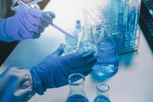 chemist,scientist hand dropping chemical liquid into test tube, science research and development concept photo