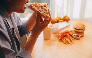 Cropped image of woman holding pizza slice at restaurant photo