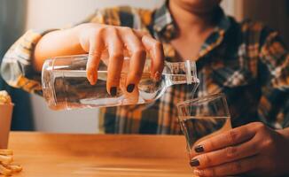 sano hermosa joven mujer participación vaso de agua foto